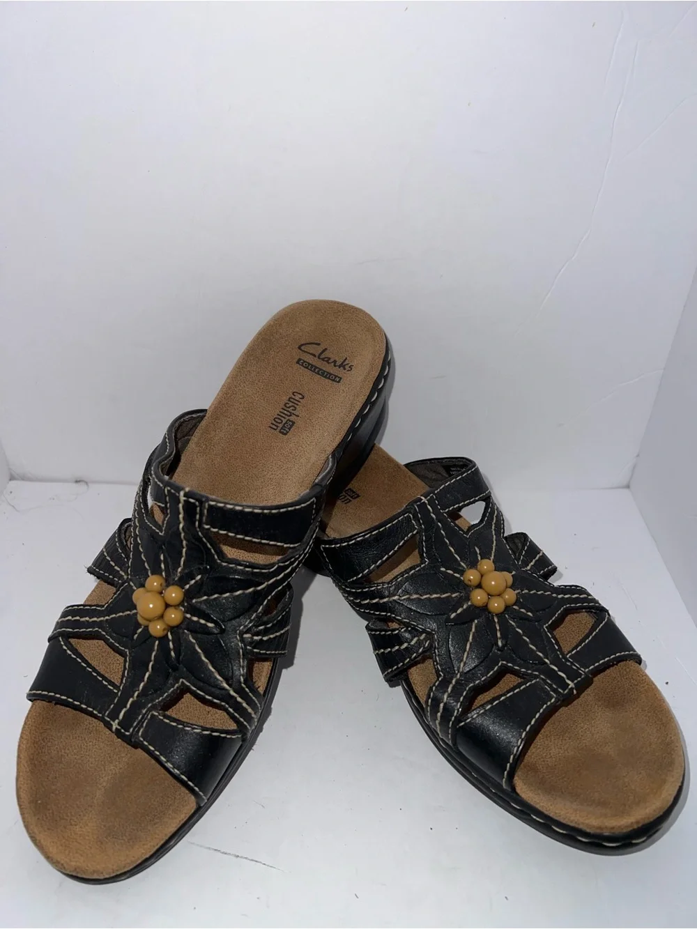 Clarks Women’s Black Leather Slip-On Sandals with Flower Accent